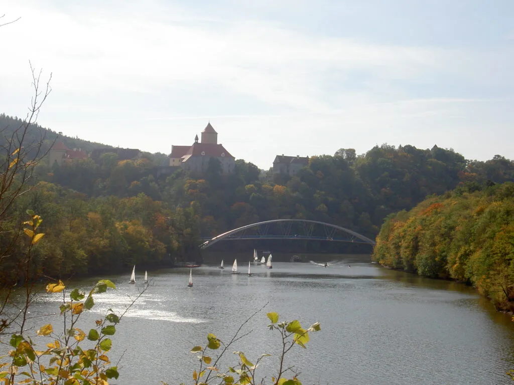 Veveří Castle can be seen across Brno reservoir, which is full of small boats.