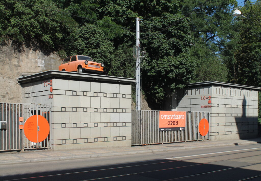 Am orange trabant sits on top of a large gate at the entrance to a cold war nuclear bunker, 10-Z Bunker, in Brno.