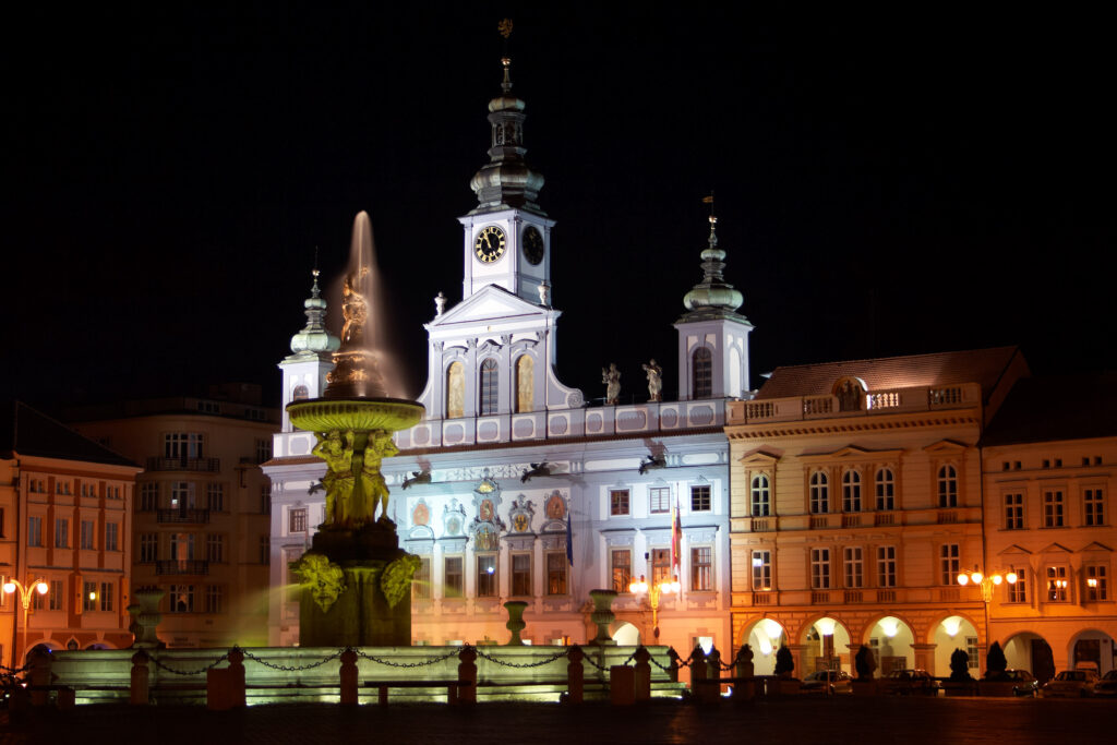 České Budějovice Town Hall is lit up at night. It's very grand, and could almost be a church.
