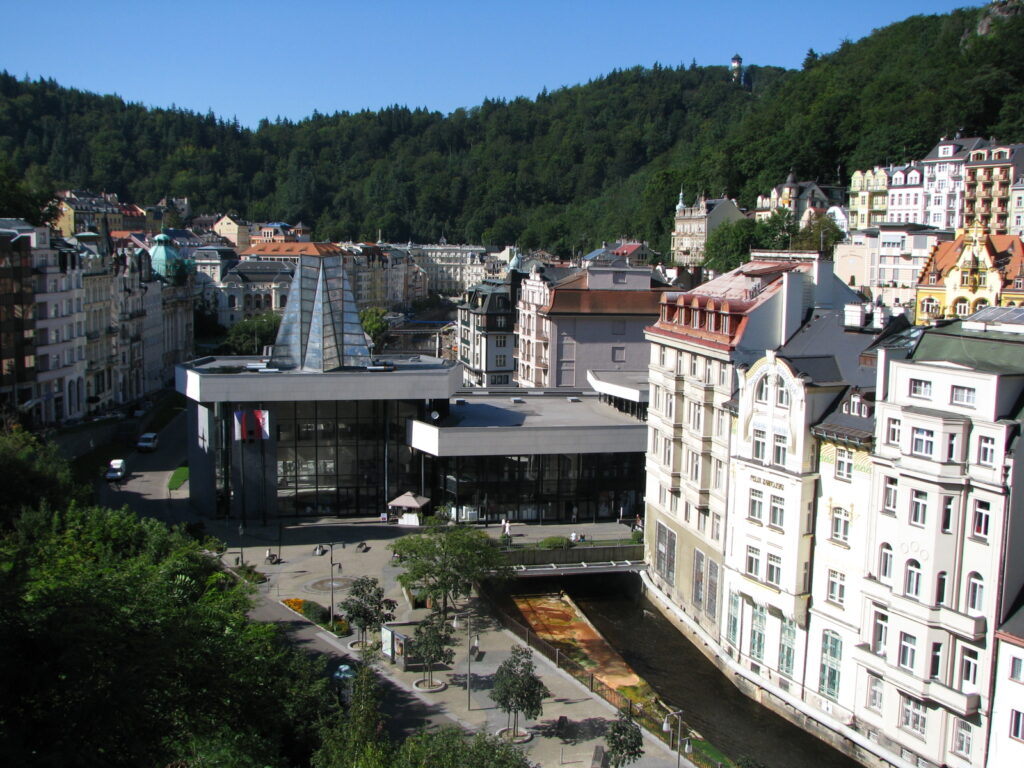 An aerial shot of the Hot Springs Colonnade in Karlovy Vary. The modern architecture stands out against the ancient buildings of the city.