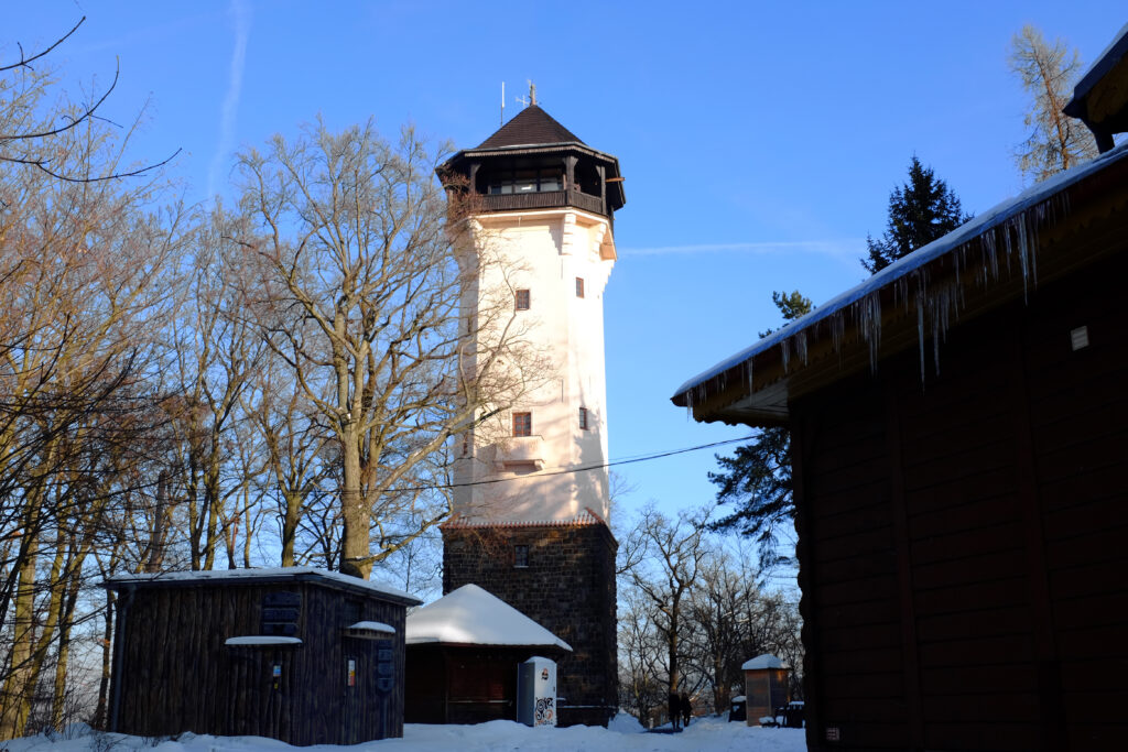 The white Diana Tower climbs out of the snow in the hills above Karlovy Vary.