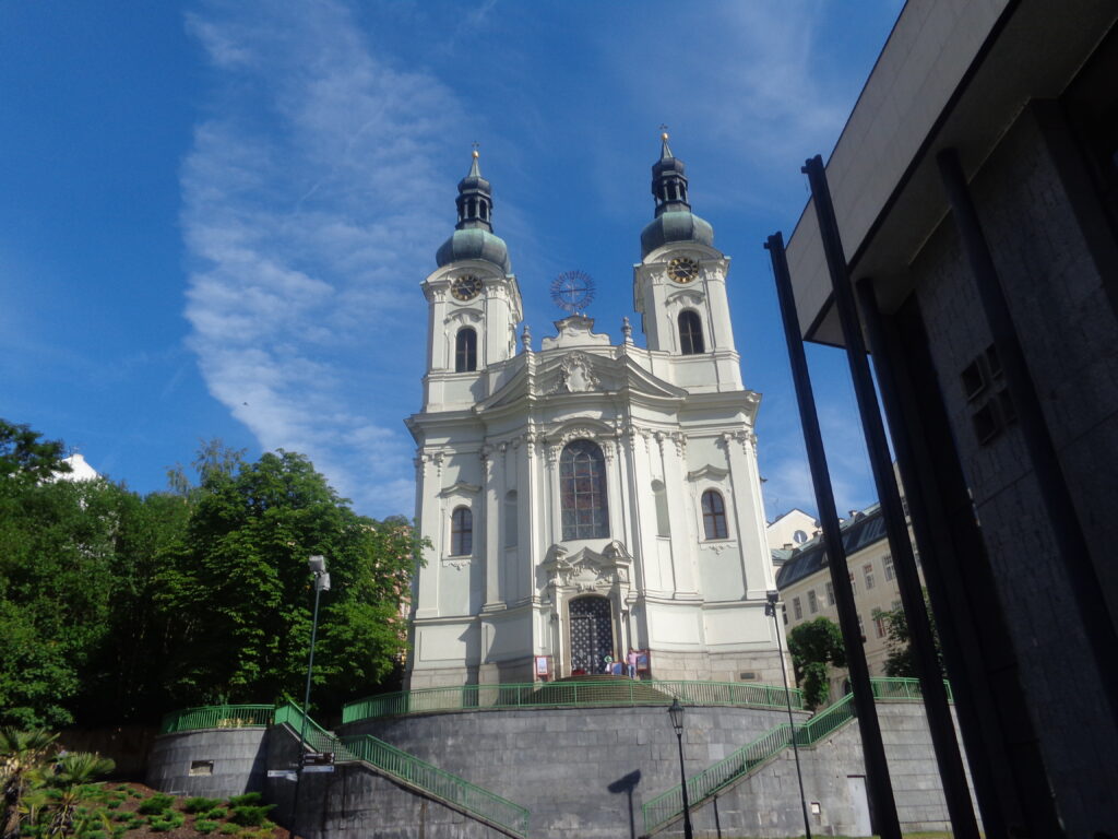 The huge, white Church of St. Mary Magdalene in Karlovy Vary with a blue sky. Wheely Tyred top attractions in Karlovy Vary