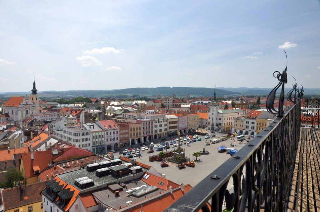 The main square of Kroměříž as seen from a balcony. There's too much car parking, and its surrounded by red roofs