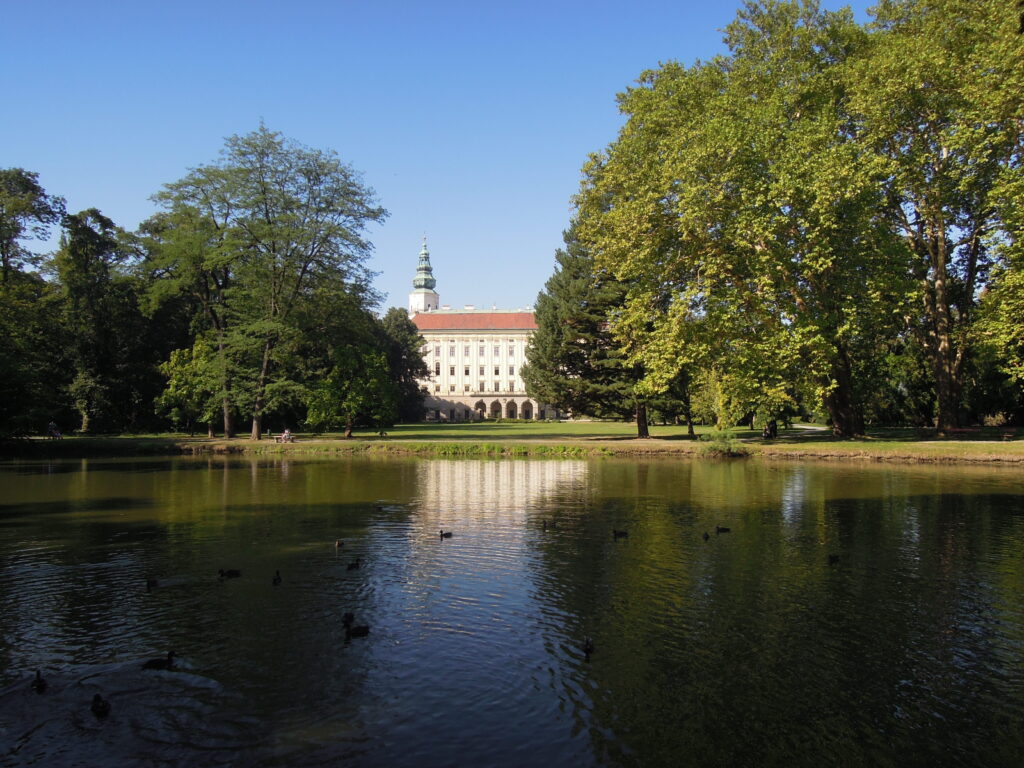The large, white archbishop's chateau can be seen across a lake. Wheely Tyred Kroměříž attractions