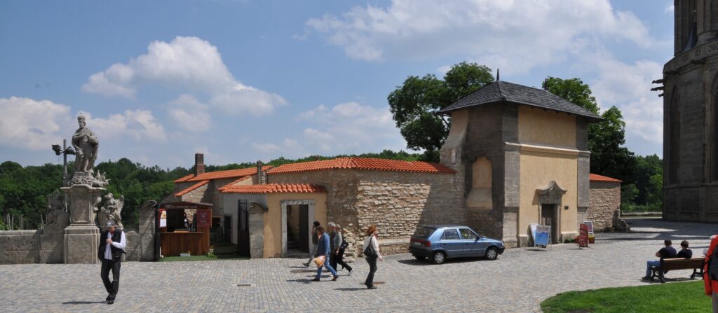 People walk past an unfinished chapel in Kutná Hora, the Corpus Christi Chapel. 