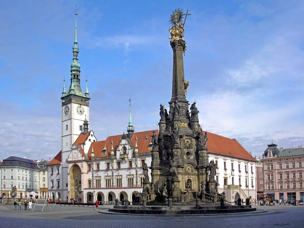 A Marian column and large, white, ornate church in Olomouc. Wheely Tyred Christmas markets in Czechia 2026
