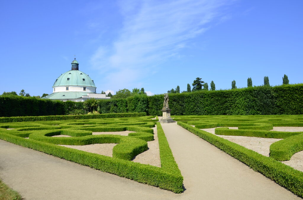 The copper roof of a rotunda can be seen across manicured gardens