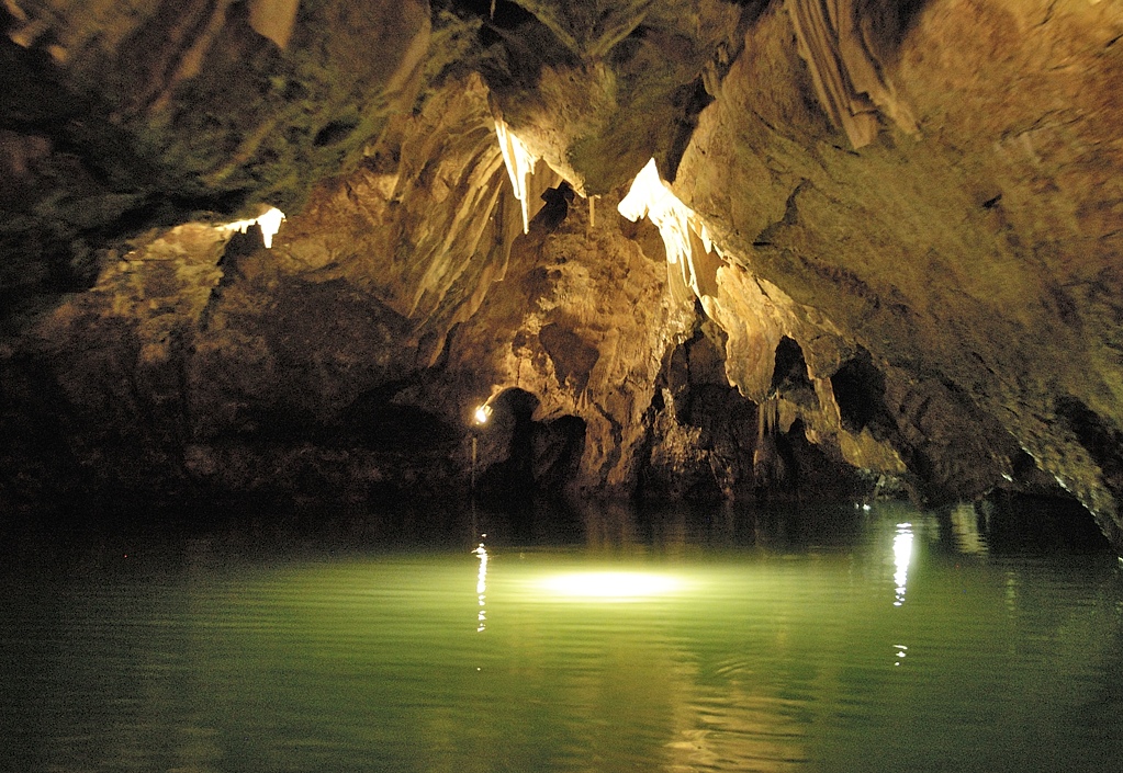 An underground lake is lit up under rock formations beneath the Moravian Karst. Wheely Tyred Moravia's iconic sights