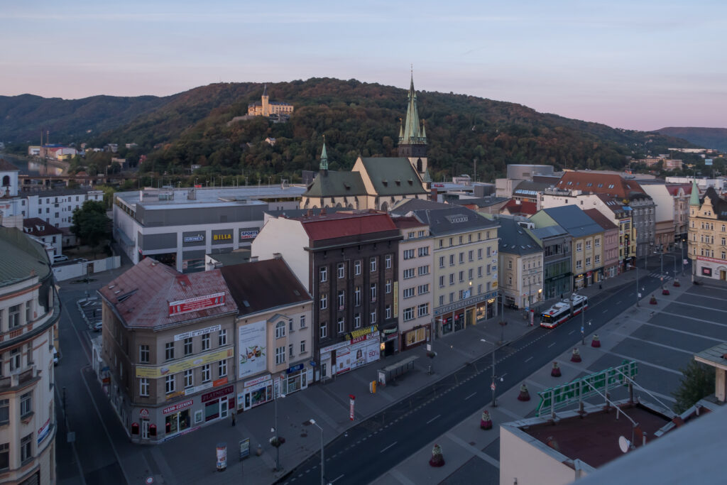 The Church of the Assumption of the Virgin Mary in Ústí nad Labem can be seen through the town, with Větruše chateau behind it.