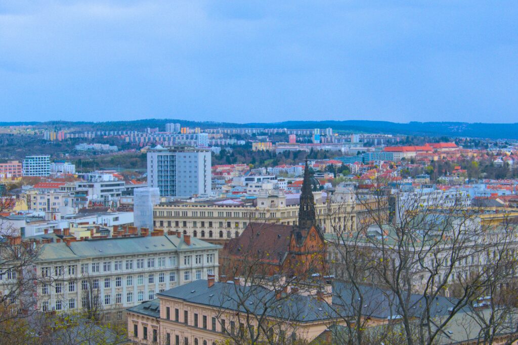 A red church is surrounded by baroque buildings, and then communist panelaks in a view from Špilberk Castle. Wheely Tyred Top attractions in Brno