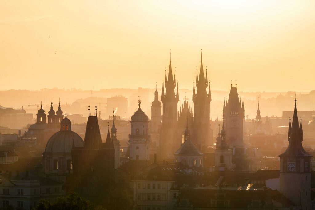 The sunrise shines through the towers of Prague Old Town
