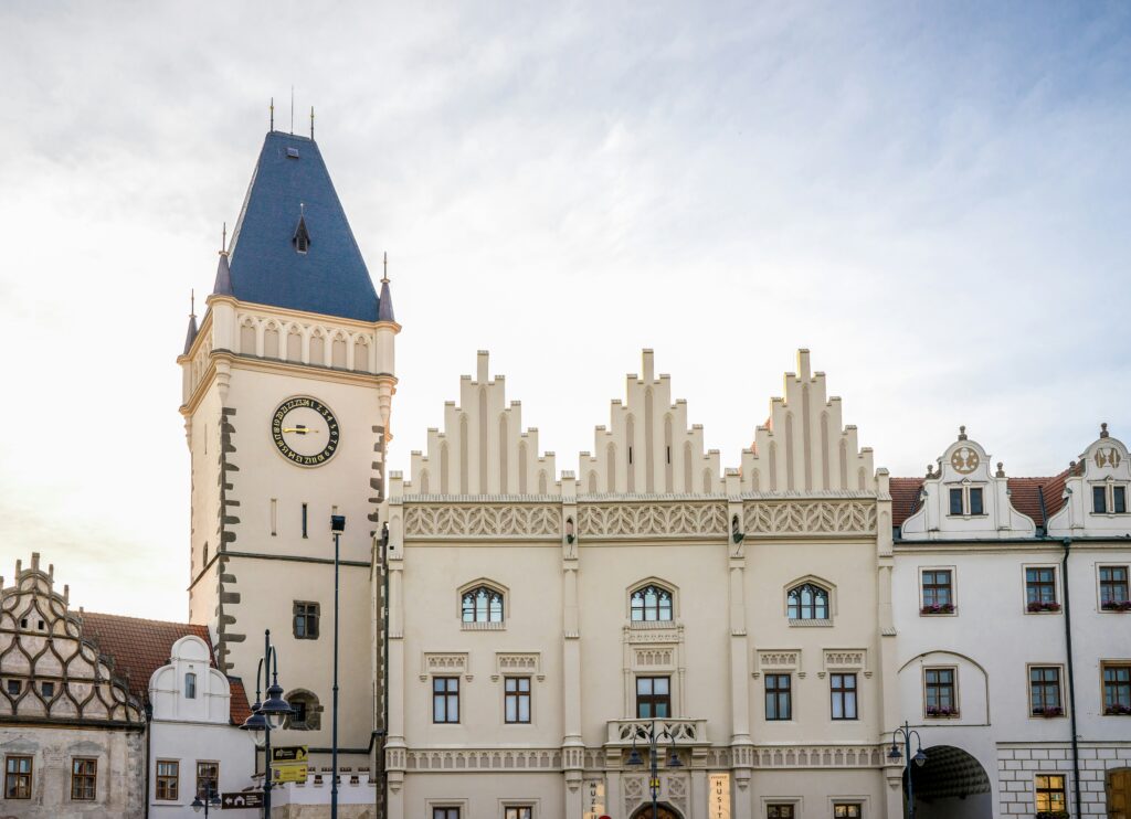 The Hussite Museum in tabor is a large white, baroque building with a clock tower. Wheely Tyred Czechia Cycling History
