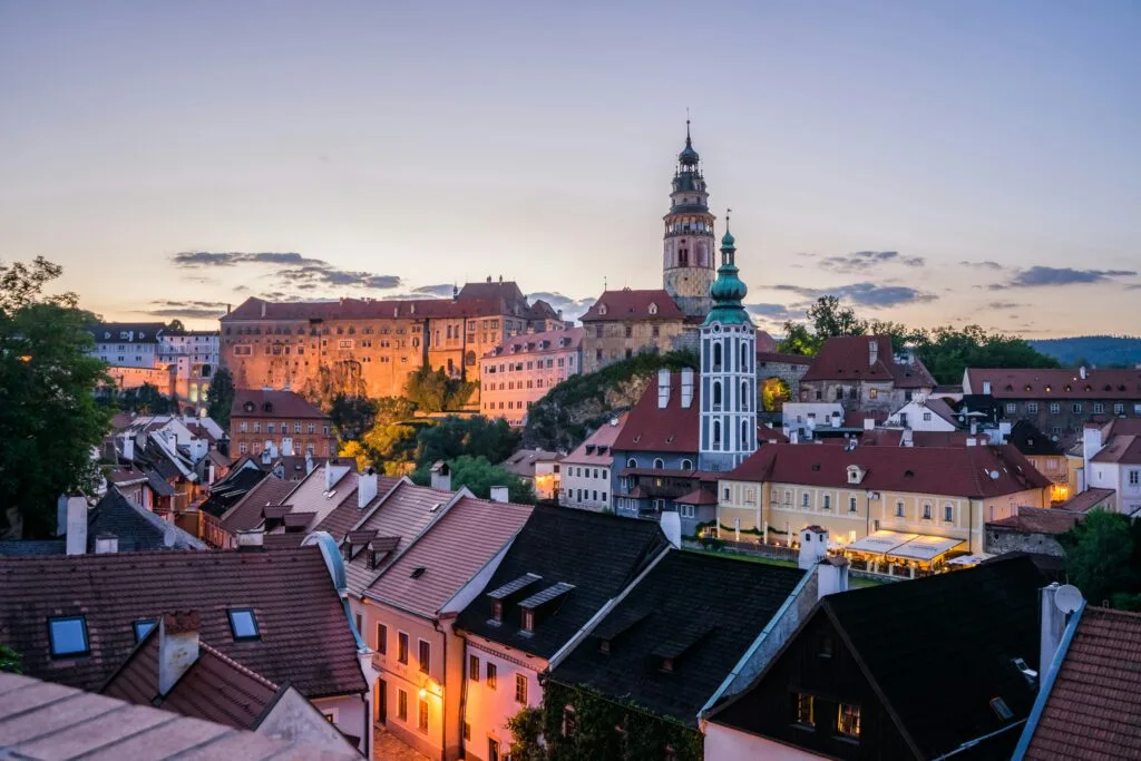A castle and chateau dominate the skyline of a red roffed city