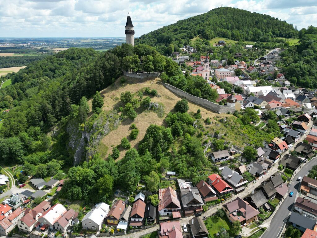 An ancient tower stands on top of a steep hill above house in Štramberk.