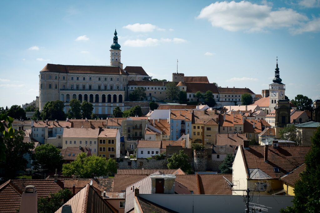 A Baroque chateua sits on top of a hill surrounded by much smaller houses and buildings