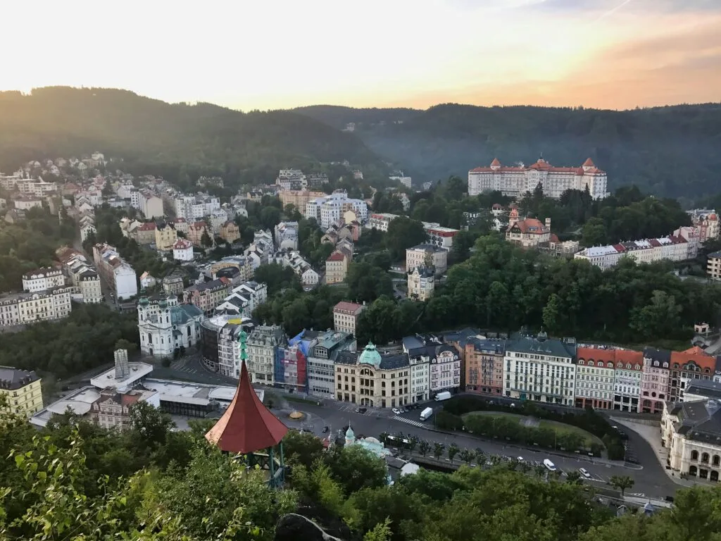 An aerial shot of the town of Karlovy Vary, Czechia showing the hills and baroque buildings.