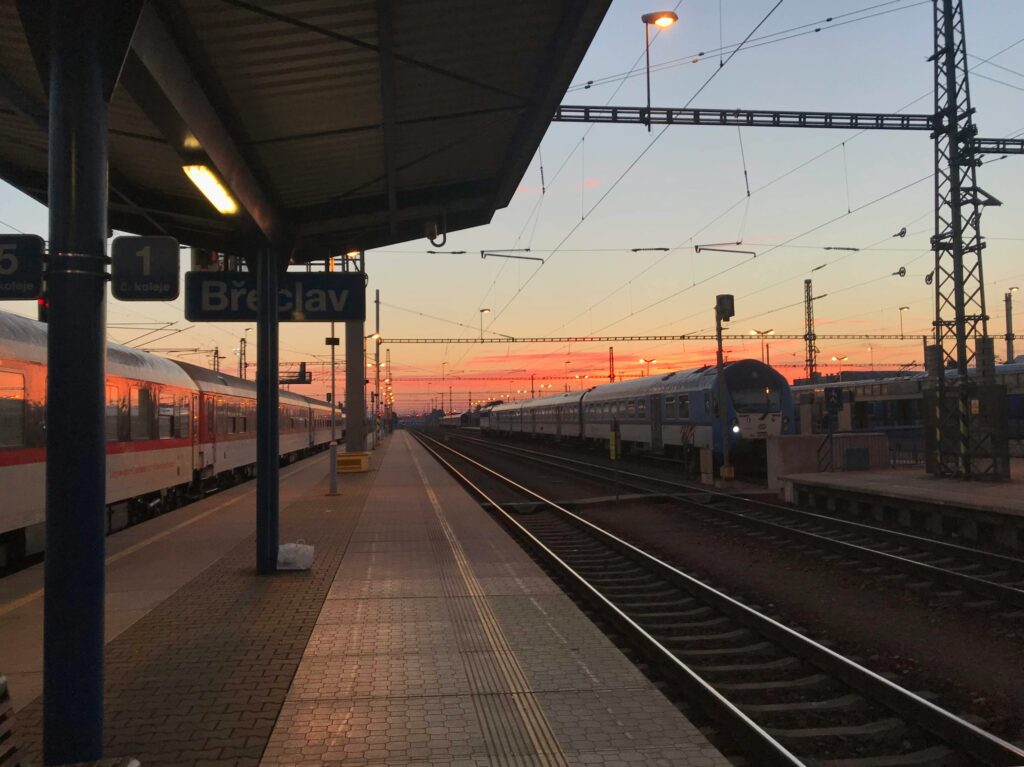 The sun sets over a train station in Břeclav, Czechia.