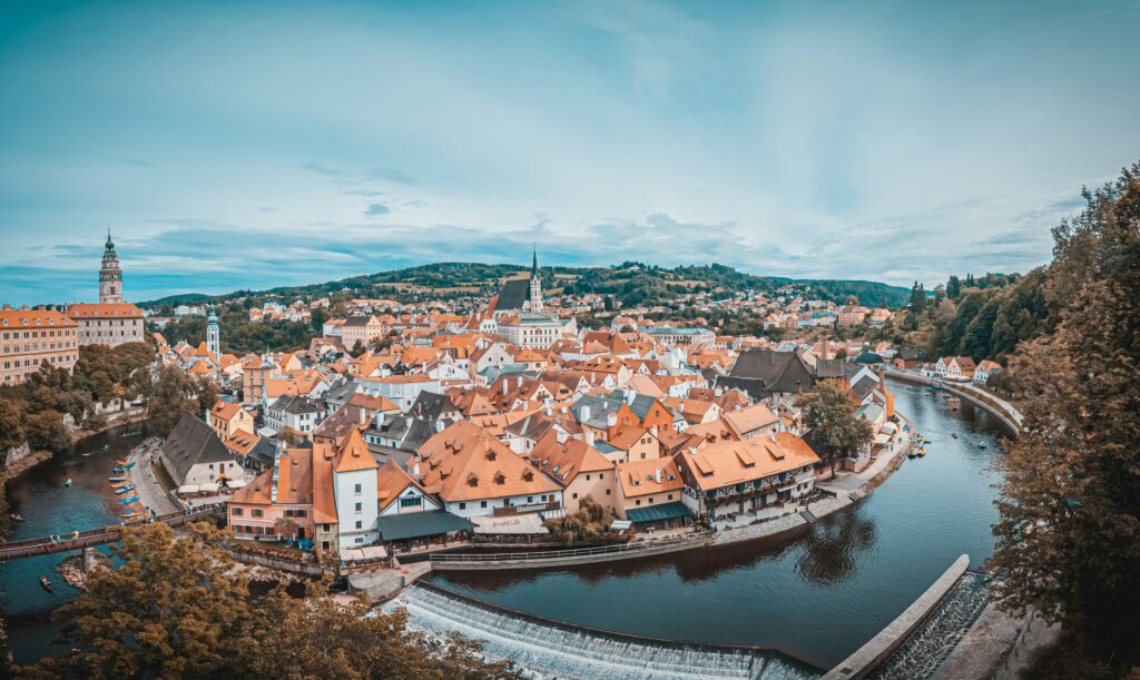 An aerial view of the red roofs of a Czech city built on the curve of a river