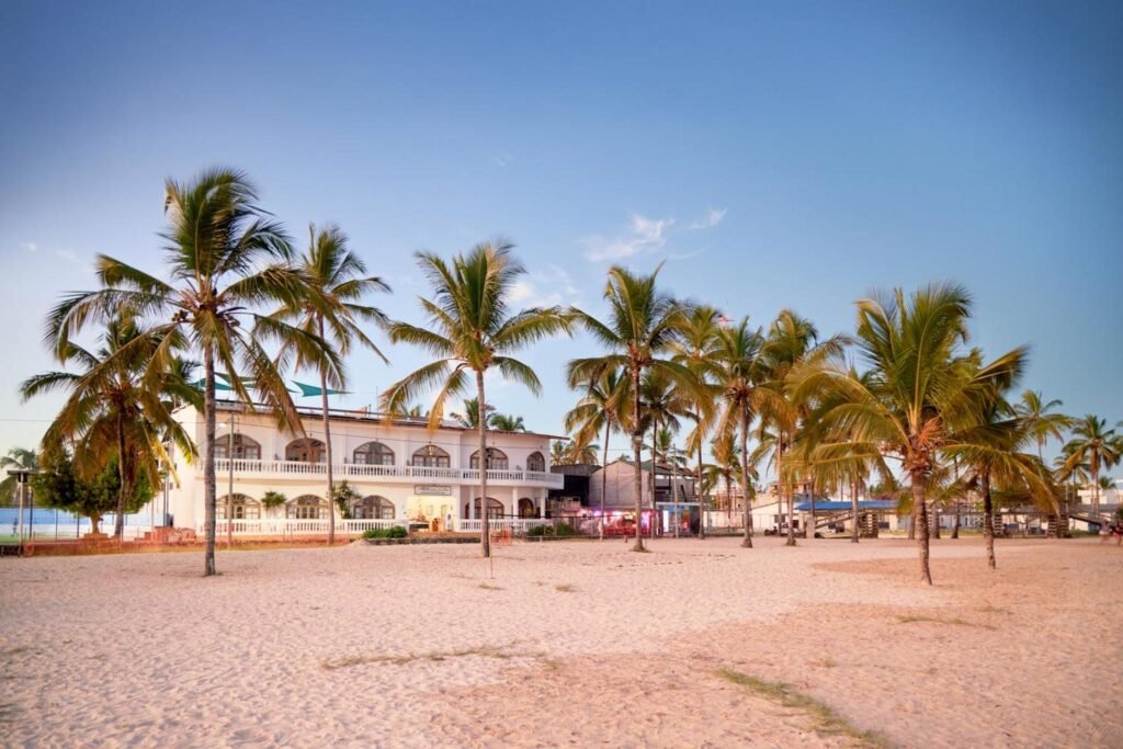The white Hotel Albemarle is surrounded by palm trees and beaches on the Galápagos Islands