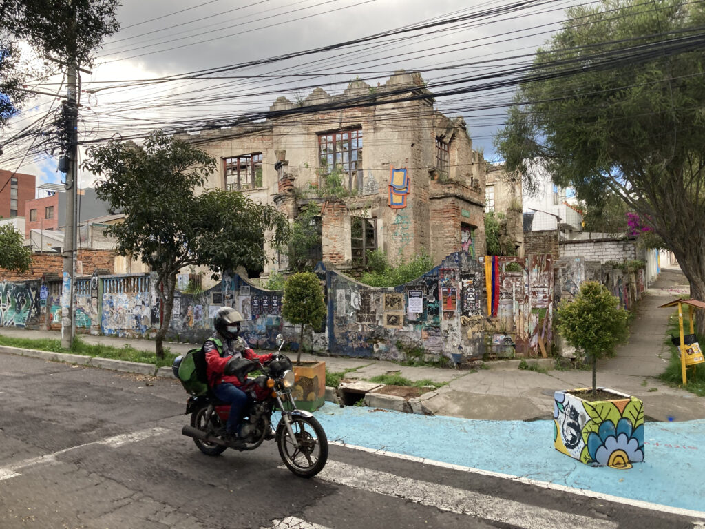 A motorcyclist drives down Valladolid Street in La Floresta, Quito.