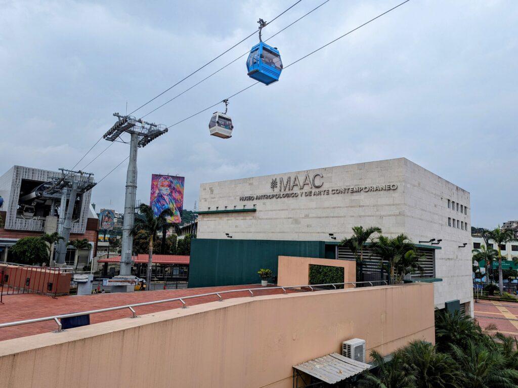 Blue cable cars pass the MAAC in Guayaquil, Ecuador.