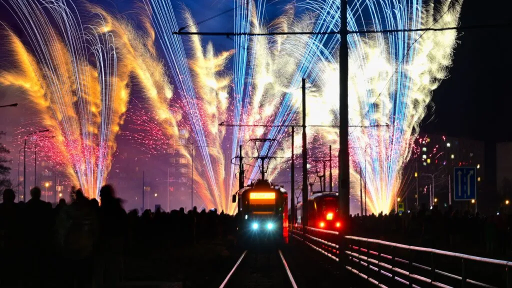 Fireworks go off as trams roll through the city of Ostrava, Czechia, at night.