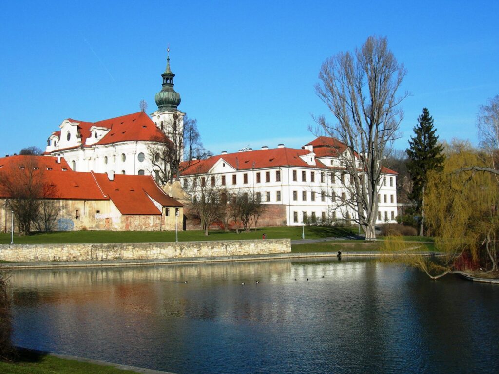 A huge white baroque monastery is built on the banks of a lake near Prague — the Břevnov Monastery.