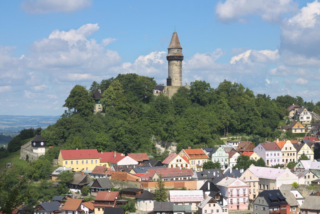 The tower of Štramberk Castle pokes through the trees on top of a hill over the village.