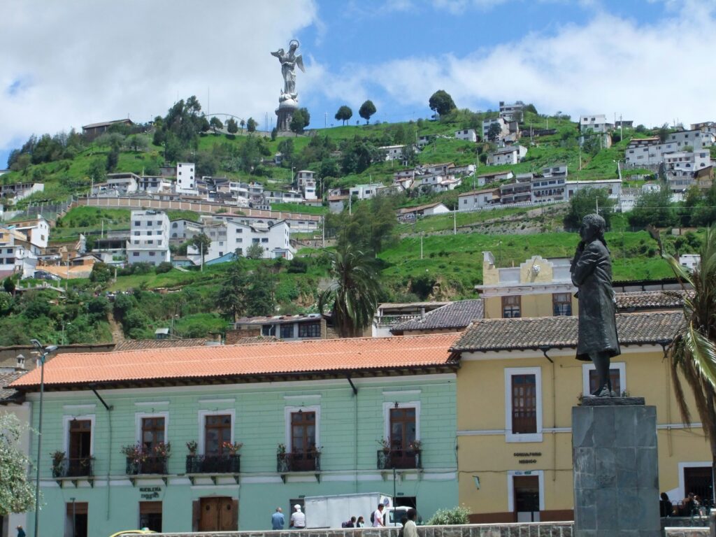 The Virgin of Quito looks down from El Panecillo onto the pastel coloured houses of the Historic Centre of Quito, Ecuador.