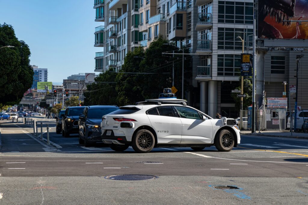 A white Waymo blocks other cars from exiting a junction in San Francisco. Wheely Tyred safe streets
