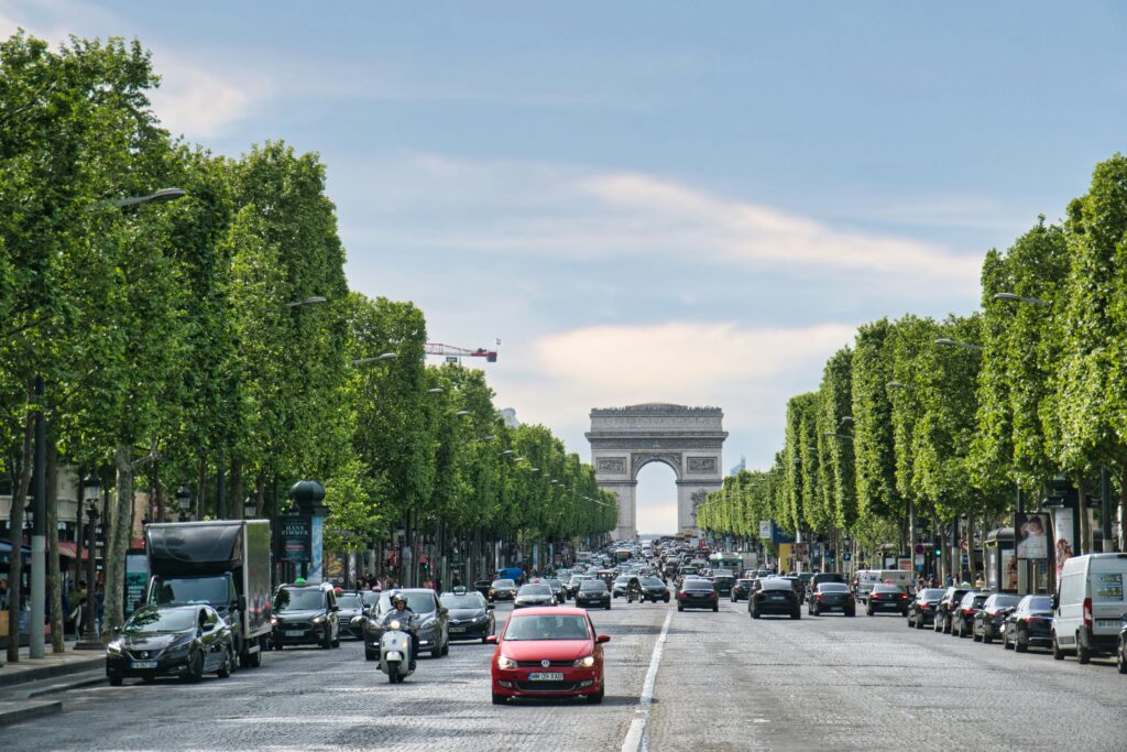 Cars drive along the Champs-Élysées in Paris, France, causing a traffic jam in front of the Arc de Triomphe.