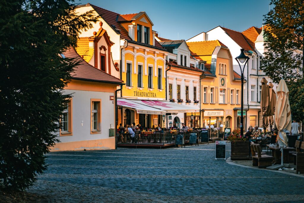 People sit outside a pub during sunset in Mělník, Czechia.