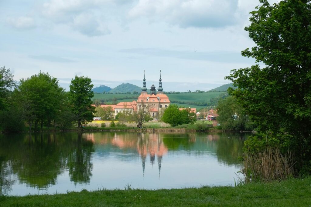 A church in Moravia, Czechia is reflected in a lake.