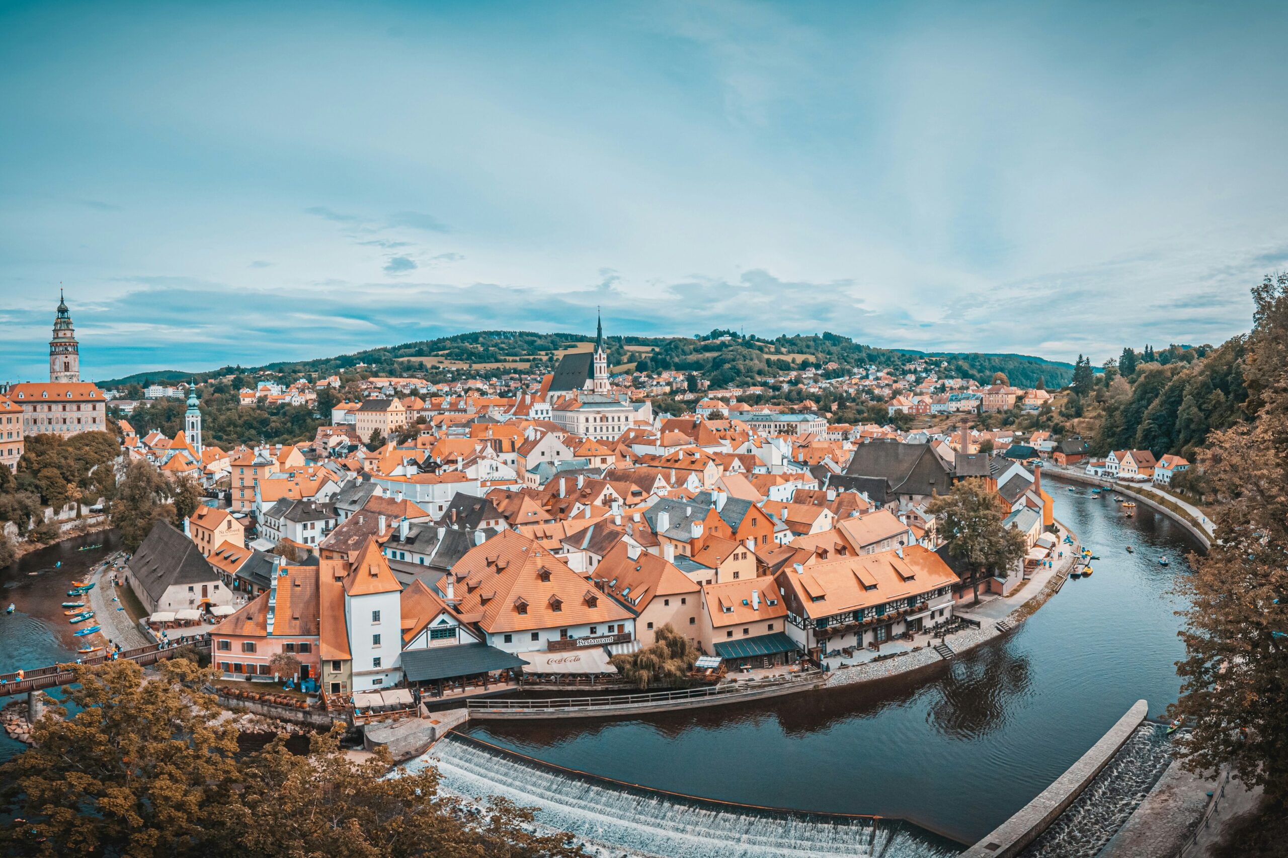 An aerial view of the red roofs of a Czech city built on the curve of a river