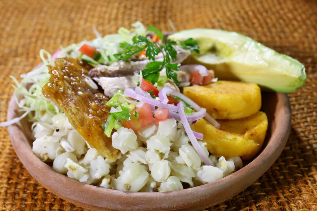 A plate of hornado, mote, potatoes and avocado. Wheely Tyred Best food tours in the Sierra