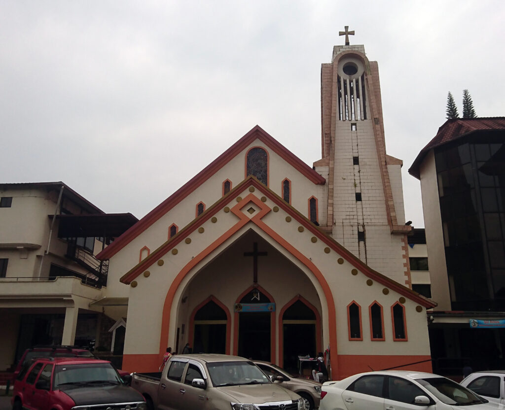 Puyo Cathedral is a modern church with dark red and cream detailing.