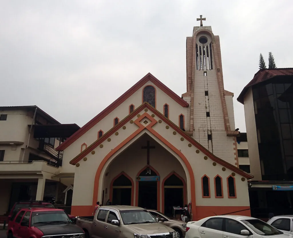 Puyo Cathedral is a modern church with dark red and cream detailing.