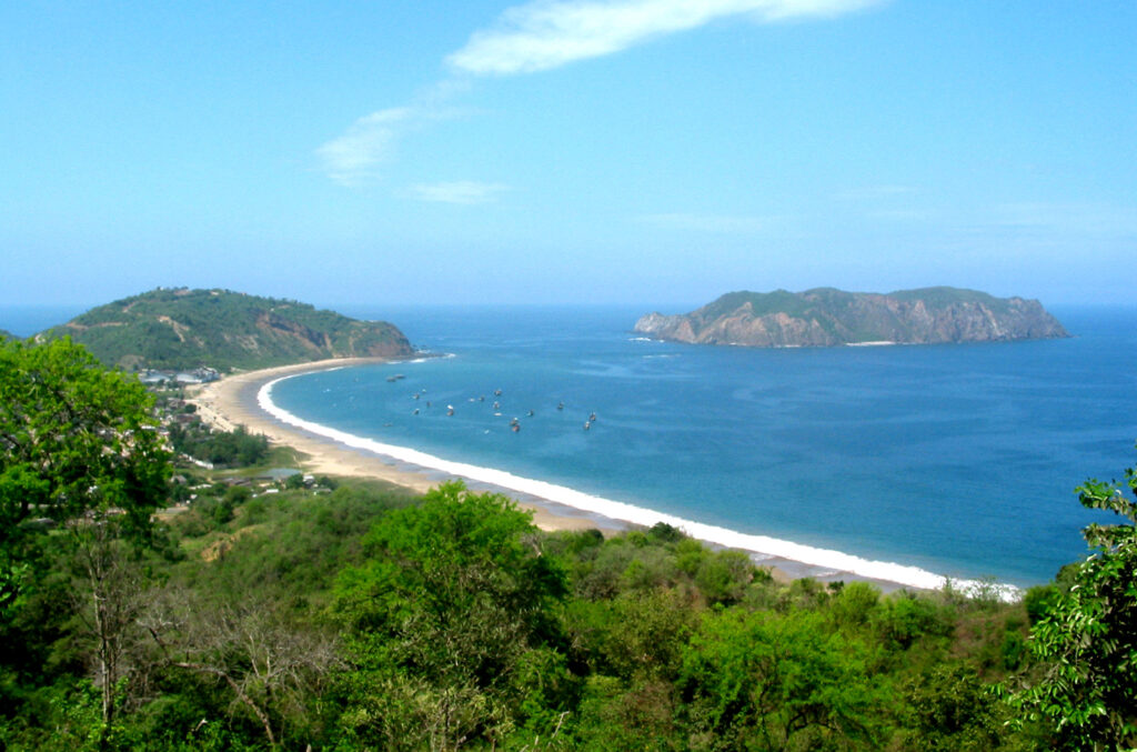 A golden beach, blue water and green forest in an aerial shot of Machalilla National Park, Ecuador.