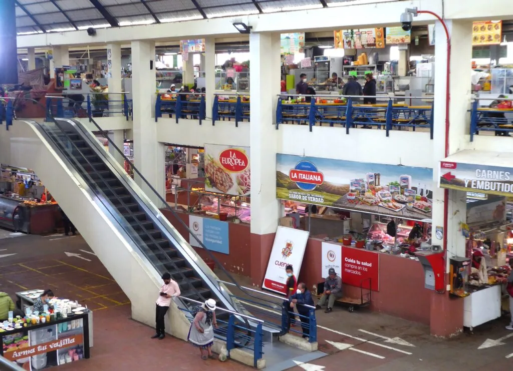 The interior of Mercado 10 de Agosto, with two floors and various vendors in Cuenca, Ecuador.