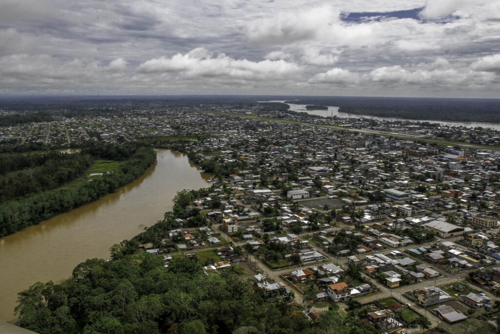 An aerial shot of Puerto Francisco de Orellana, Coca, with a brown river running through it.