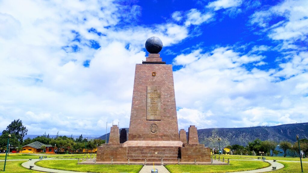 The Mitad del Mundo monument under a blue sky in Quito, Ecuador