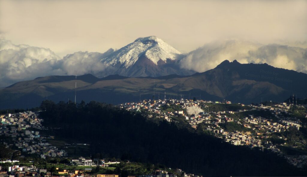 The snowcapped Volcán Cotopaxi rises through the clouds above Quito, Ecuador. Wheely Tyred What to eat in the Ecuadorian Sierra