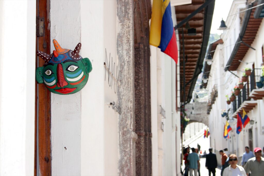An indigenous face mask hangs from a door frame in the historic centre of Quito, Ecuador.
