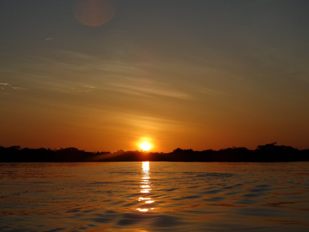 The sun sets over a lake in Ecuador. Wheely Tyred best things to do in Cuyabeno