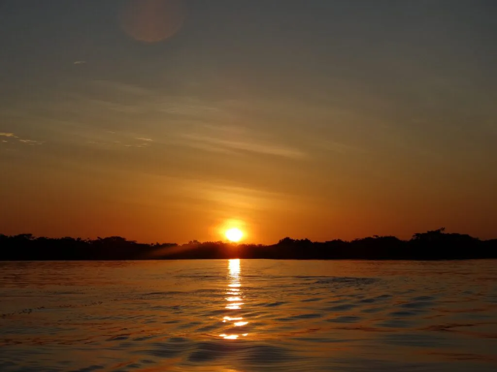 The sun sets over a lake in Ecuador. Wheely Tyred best things to do in Cuyabeno