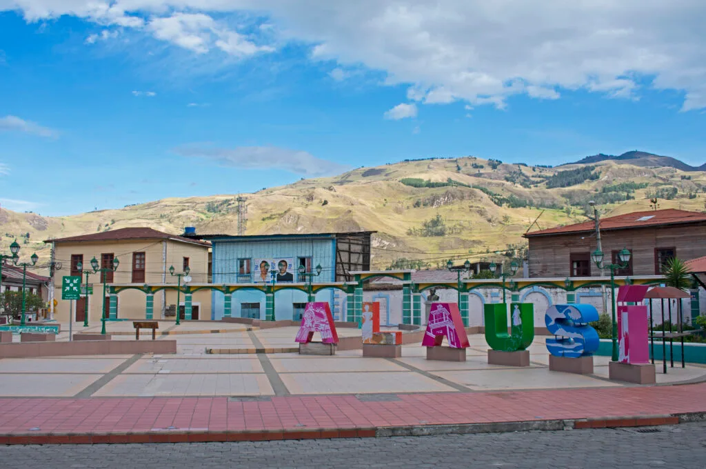 The main square of Alausi, with a sign of the village’s name and colonial buildings
