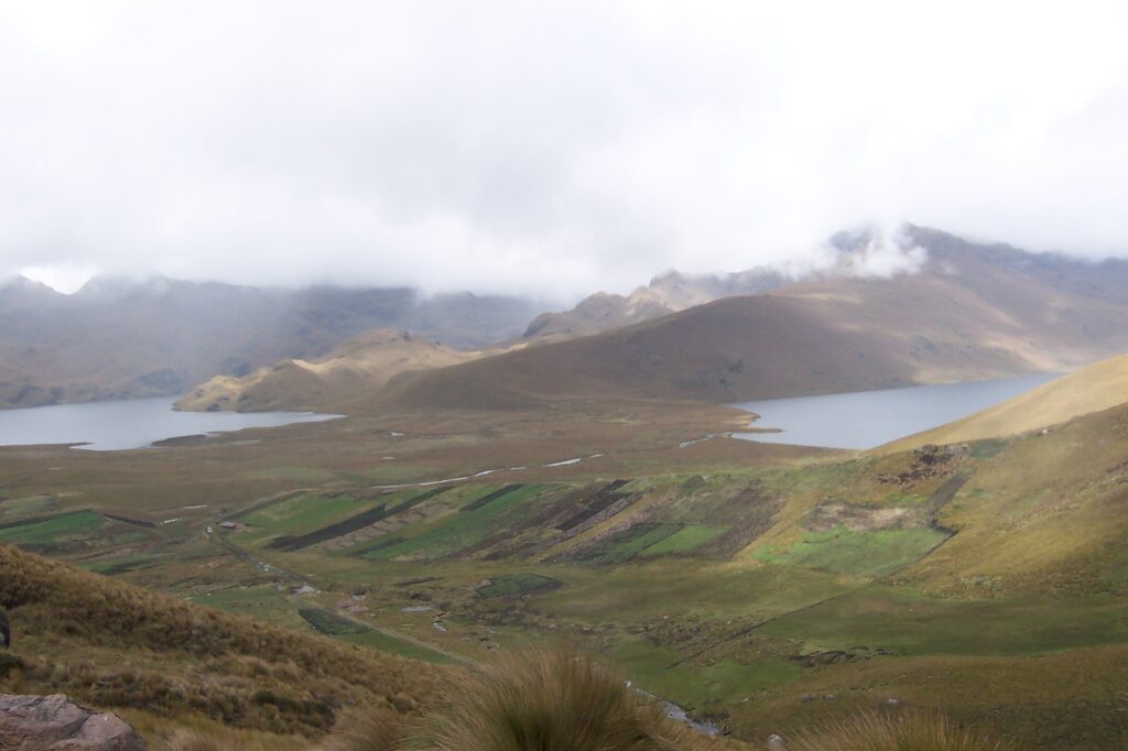 Lagunas de Ozogoche with low clouds and surrounded bby green pasture in the Ecuadorian Sierra