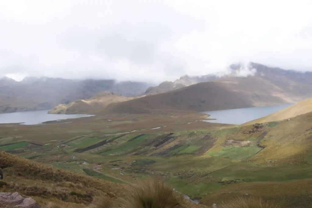 Lagunas de Ozogoche with low clouds and surrounded bby green pasture in the Ecuadorian Sierra