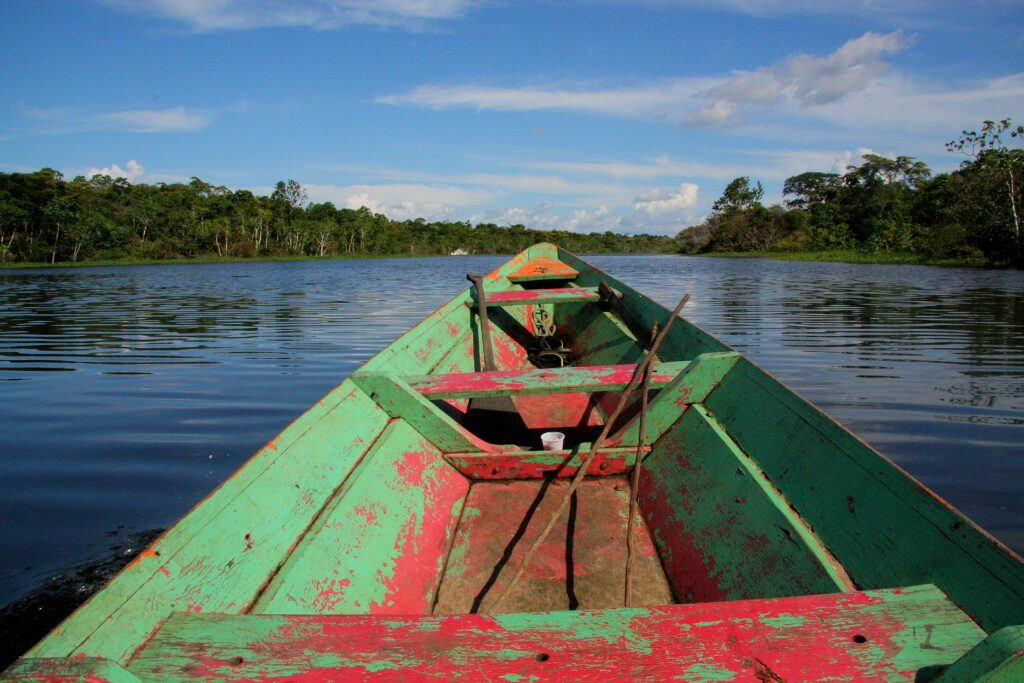 A green and red wooden boat floats down the Amazon River near Manaus, Brazil. Wheely Tyred Amazon Ecuador food guide