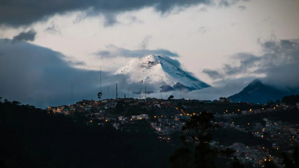 The peak of Cotopaxi Volcano can be seen towering over a city in Ecuador